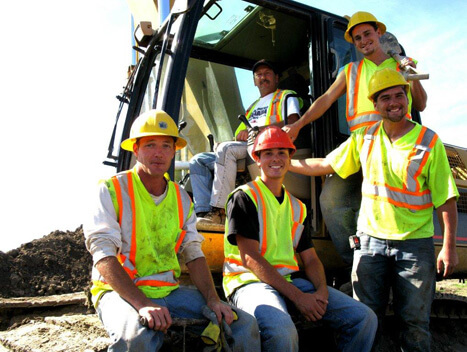 Two CAT excavators placing underground infrastructure in a residential development